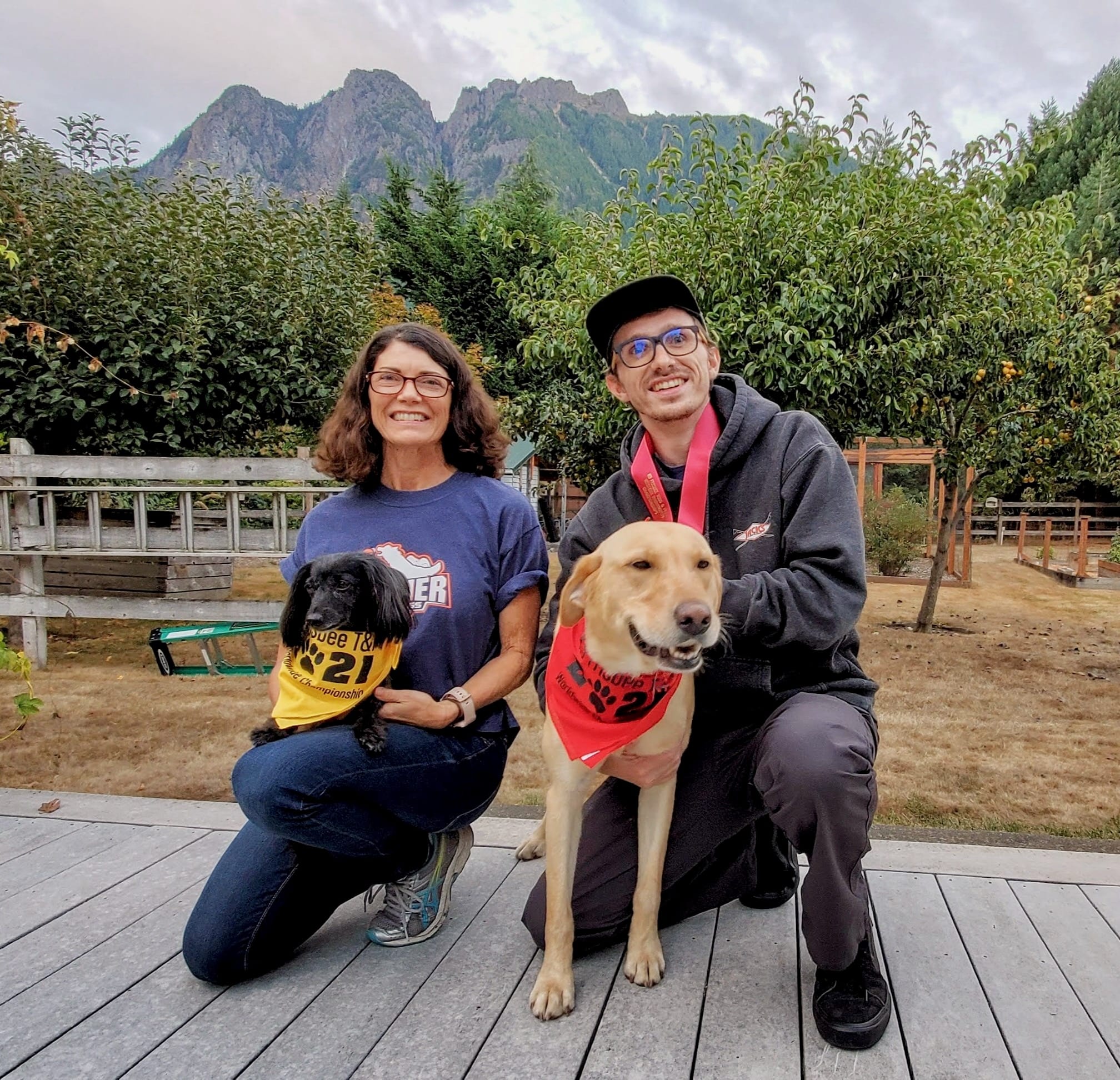 a mother and son posing with their dogs